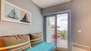 A room with a bed, a sliding glass door to an outdoor area, and a framed picture on the wall. - Studio Terrace 263 by the Sea (La Grande-Motte)