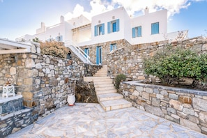 A stone staircase leading to a white building with blue shutters. - Lunar Villa (Mykonos)