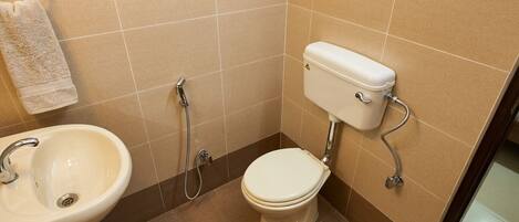 A bathroom with a toilet, bidet, and sink.