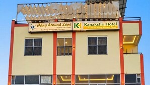 Ein mehrstöckiges Gebäude mit Hinweisschildern für Hang Around Zone und das Kanakshri Hotel.