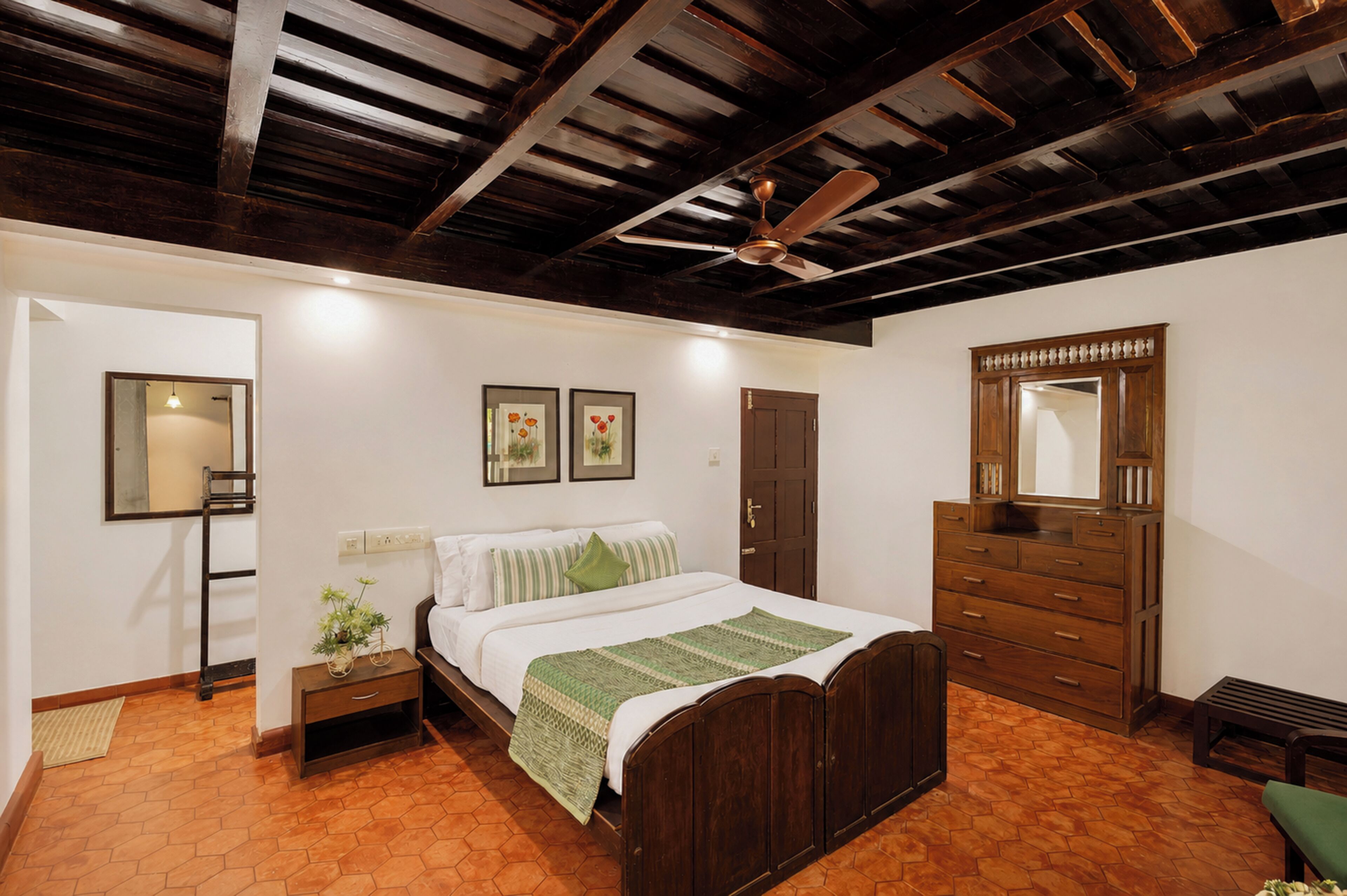 A bedroom with a wooden bed, a dresser, a mirror, and a ceiling fan.