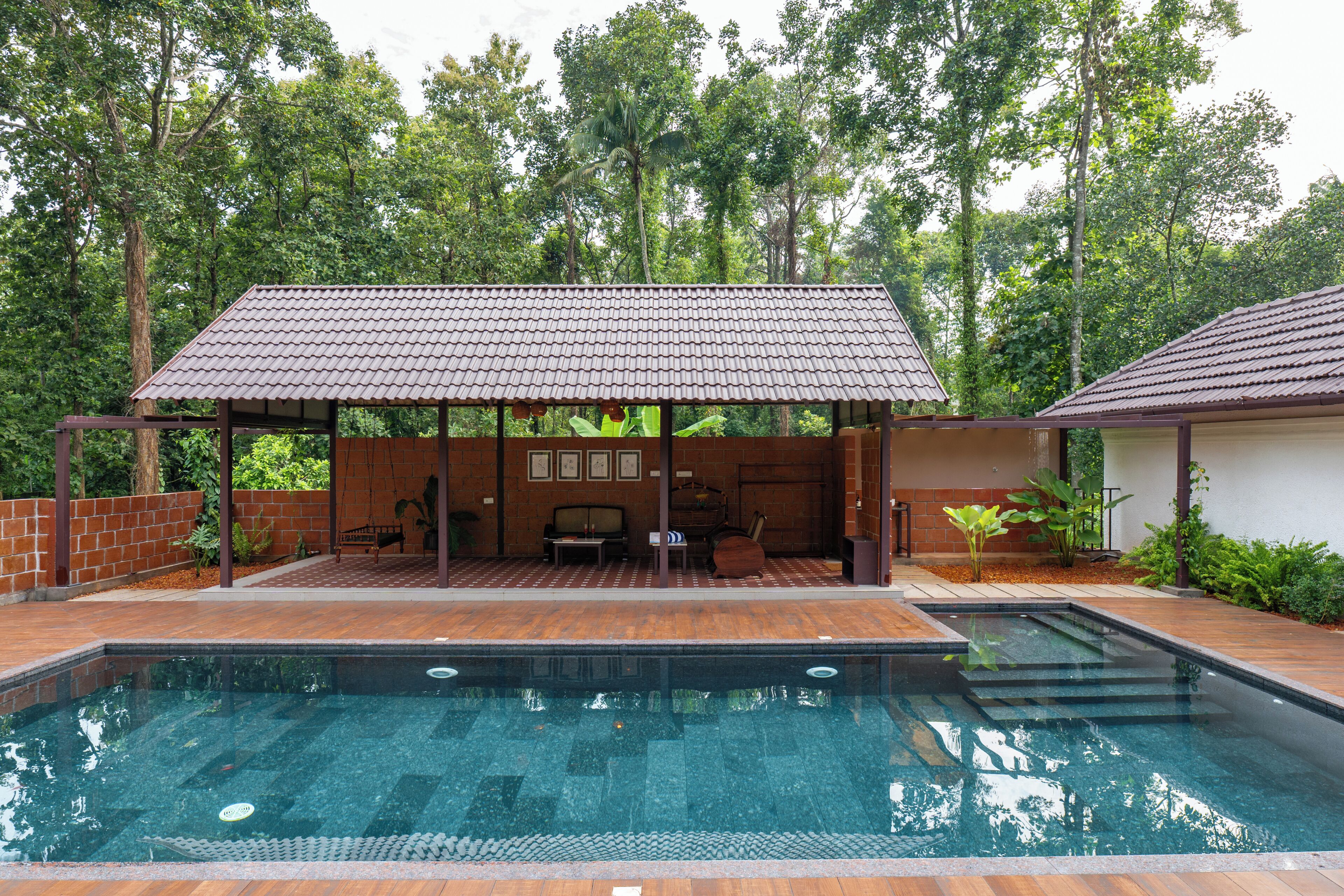 A pool area with a covered seating area and a pool.