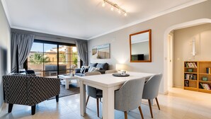 Uma sala de estar moderna com uma mesa de jantar, sofá e estante.