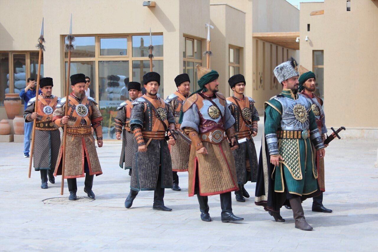 A group of people in historical costumes standing in a courtyard.
