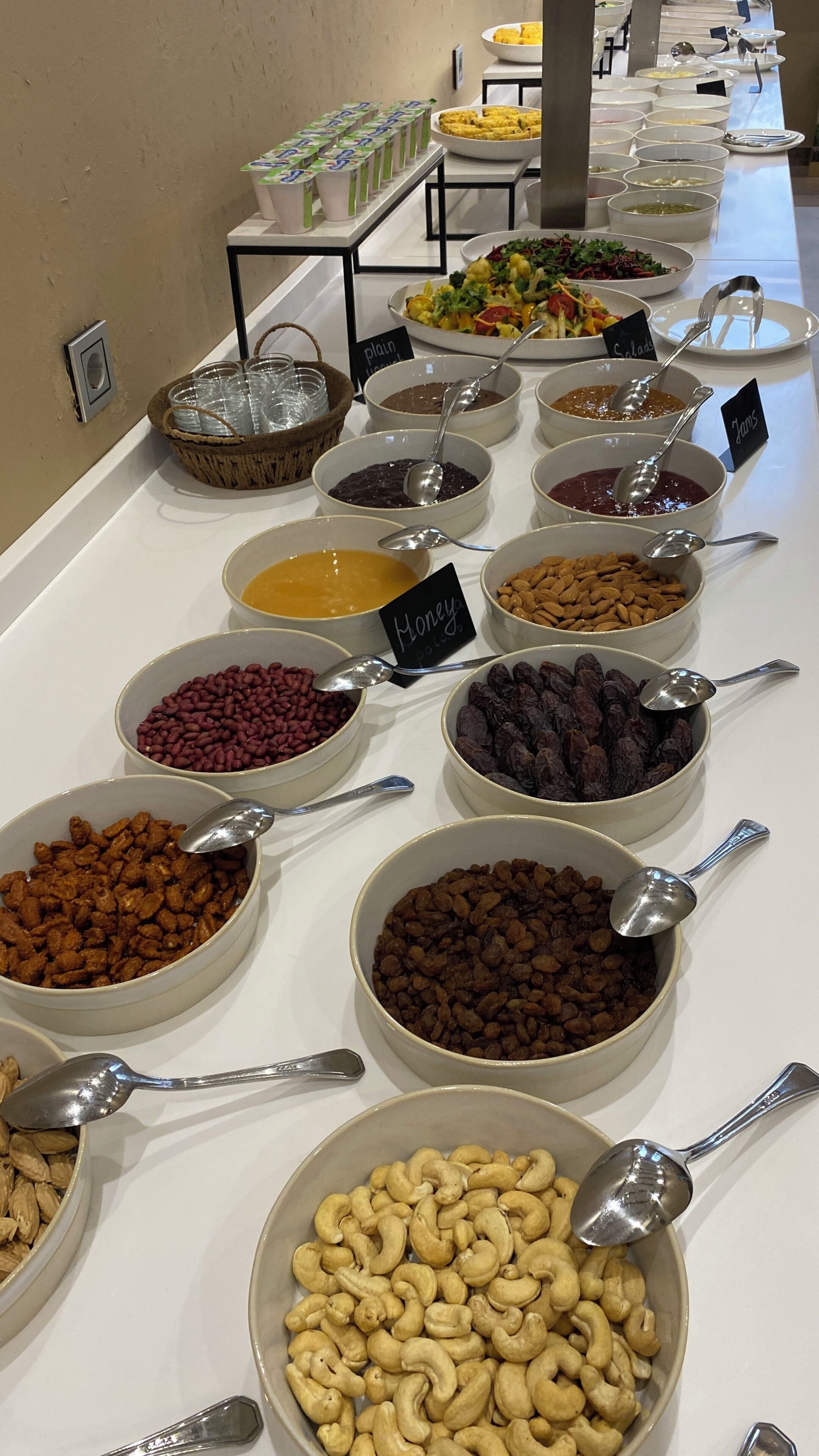 Un buffet proposant une variété d’aliments, notamment des haricots, des noix et des fruits.