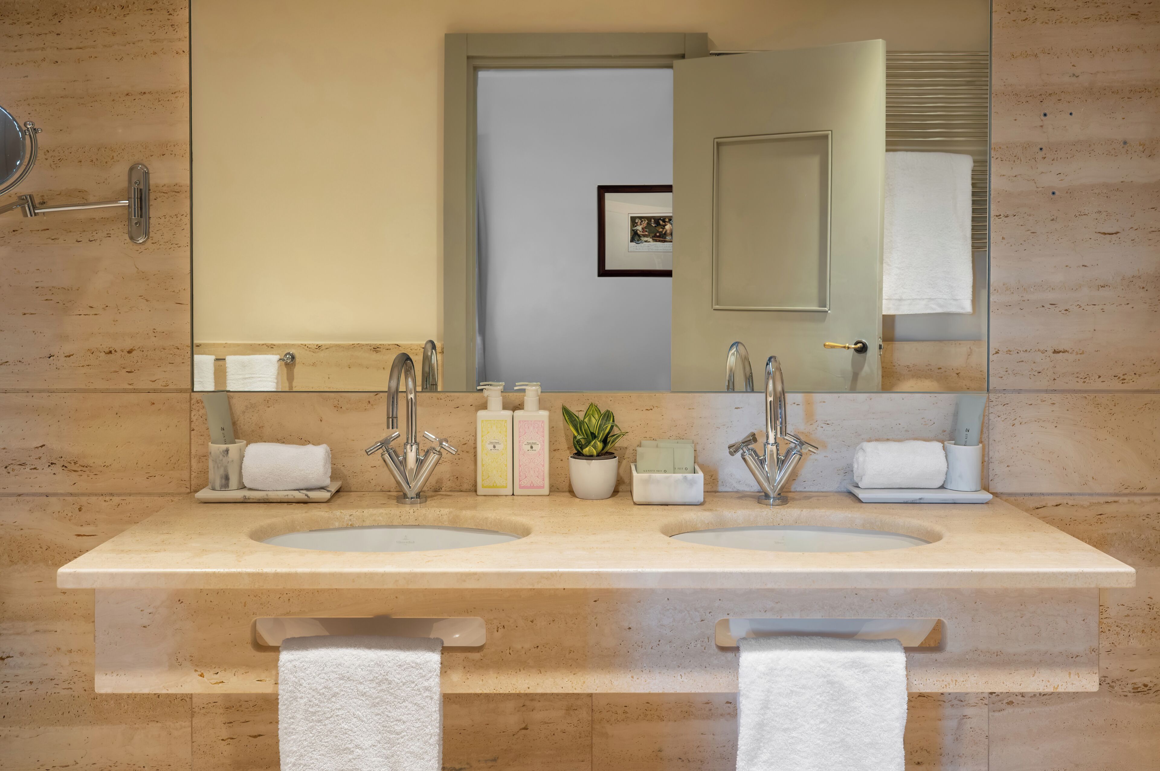 Un bagno con due lavandini, un ampio specchio e un porta asciugamani.