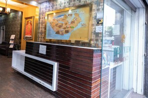 A reception desk with a map, a framed picture, and a sign indicating a residency. - Park View Residency (Bhuj)