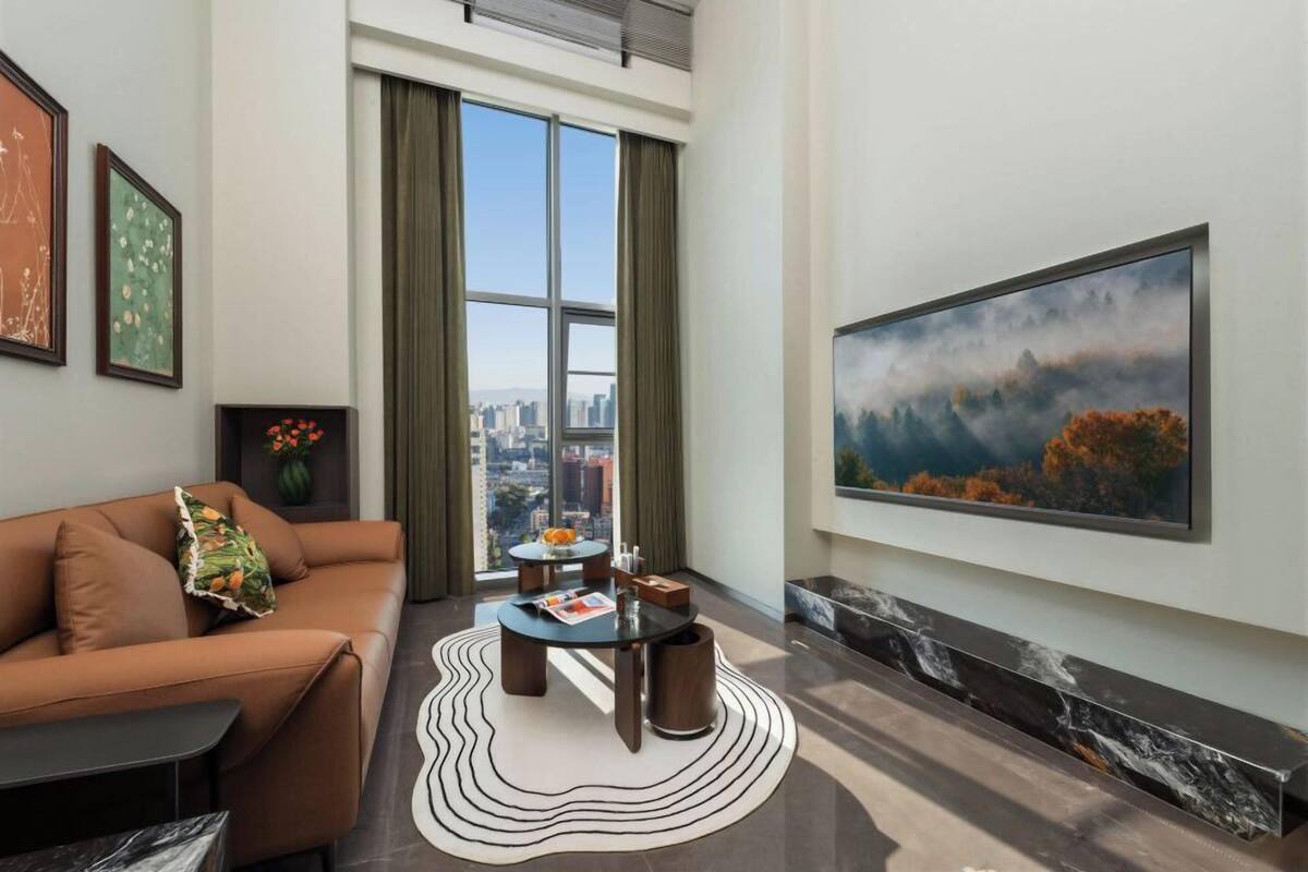 Uma sala de estar moderna com sofá, mesa de centro e um quadro.