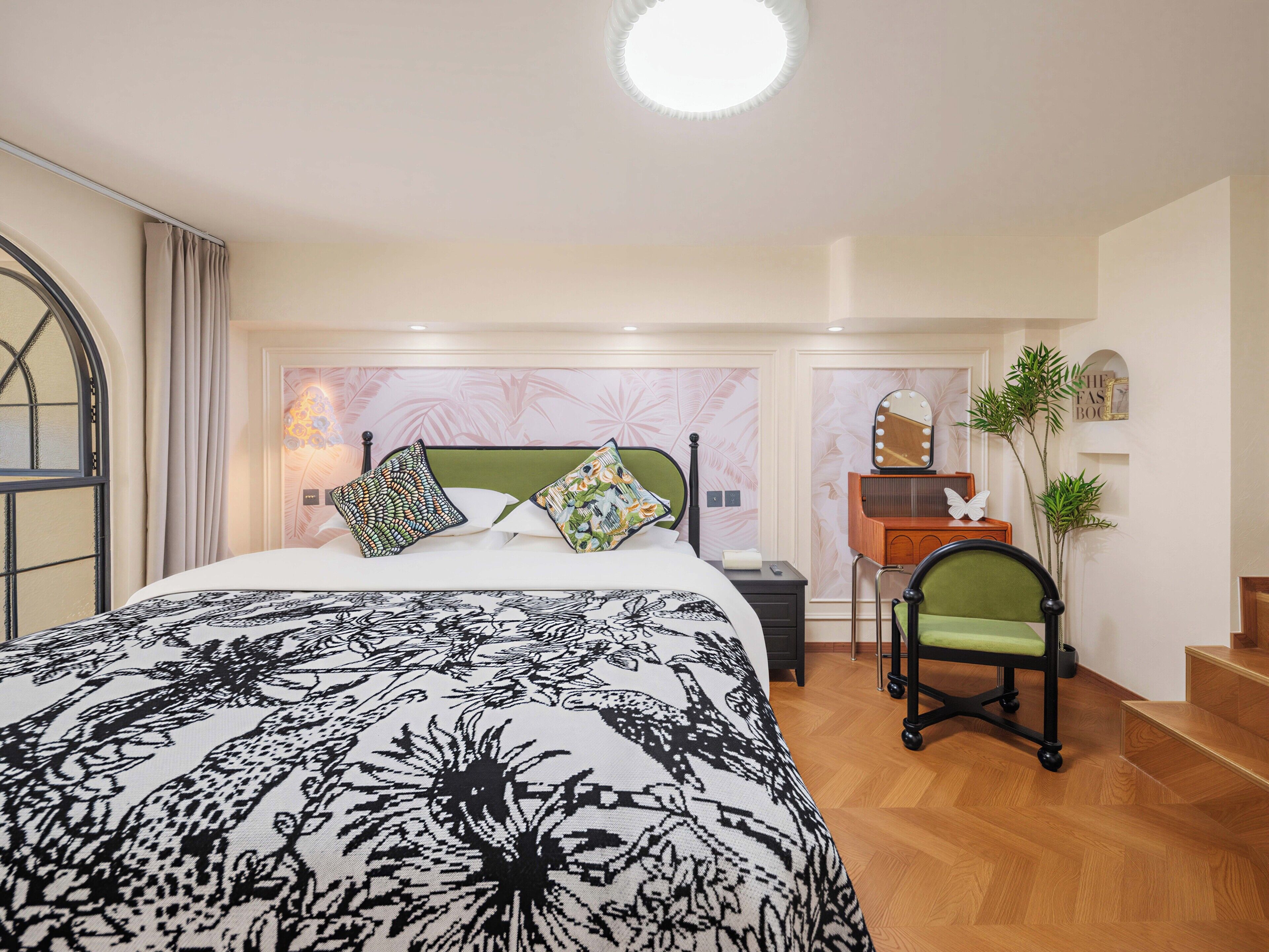 Un dormitorio con cama, una silla, un tocador con espejo y una escalera.