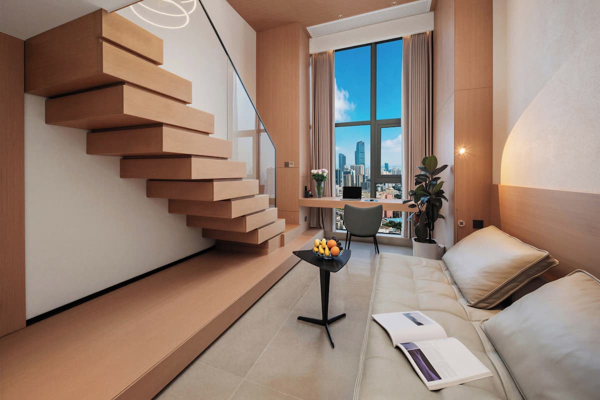 Um apartamento moderno com escada flutuante, vista da cidade, sofá e uma pequena mesa com frutas.