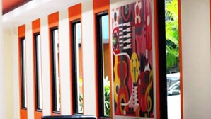 A modern interior with a row of windows, a seating area, and a colorful abstract painting on the wall.