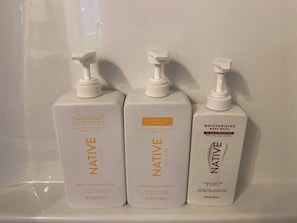 Drei Flaschen Haarpflegeprodukte von Native auf einem Regal.