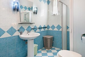 A bathroom with a sink, mirror, shower, and toilet. - Salento Short Let Apartment: Spacious, Bright, Private Terrace, Garden, Air Conditioning (Copertino)