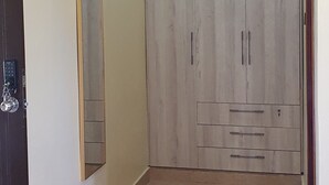 Una habitación con armario, espejo y balanza en el suelo.
