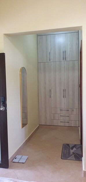 Habitació amb armari, mirall i una bateda al terra.