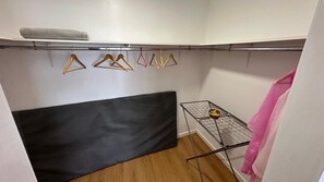 A small room with a black sofa, a metal drying rack with clothes, and a white wall. - Modern apartment with a terrace in the heart of town (Vila Franca Do Campo)