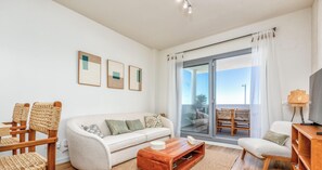 A modern living room with a sofa, chairs, a coffee table, and a balcony with a view. - Valle Romano | Pool - terrace - gym (Estepona)