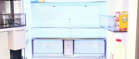 A refrigerator with a water filter compartment, a milk carton, and a coffee maker.