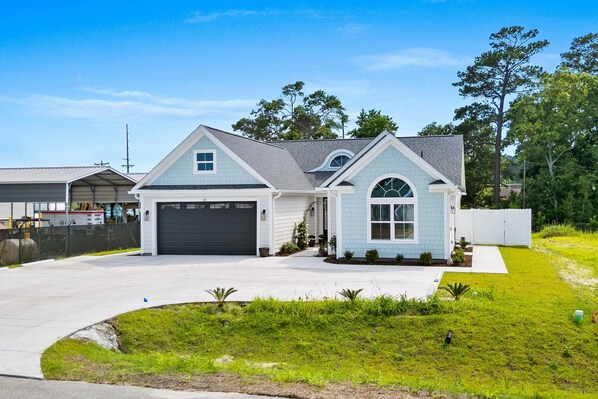 A single-story house with a garage, a driveway, and a well-maintained lawn. - Riviera Suites | Near Beach & Boardwalk (Myrtle Beach)