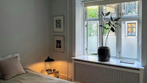 Una camera da letto con un letto, una finestra vista, un termosifone e un comodino con una lampada.