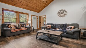 Ein gemütliches Wohnzimmer mit zwei Sofas, einem Couchtisch und einem Wanddekor.