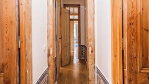 Ein Korridor mit Holztüren und Fliesenboden.