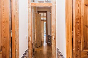 A hallway with wooden doors and a tiled floor. - Spacious 4-Bedroom Historic Apartment with Elevator (Lisboa)