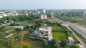 A residential area with modern houses, a road, and distant high-rise buildings.
