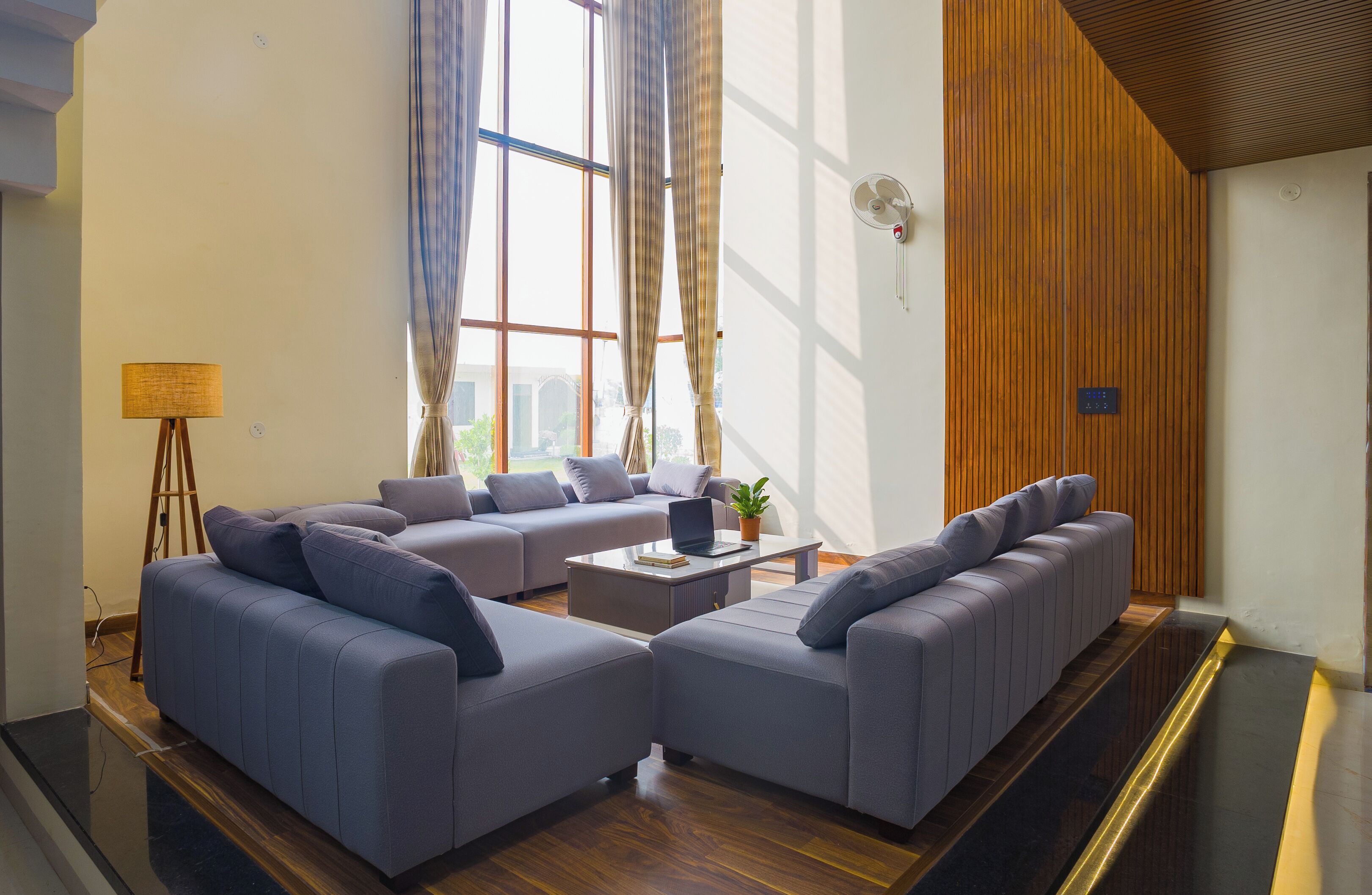 A modern living room with two sofas, a coffee table, and a lamp.