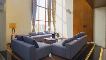 A modern living room with two sofas, a coffee table, and a lamp.