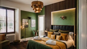 A bedroom with a bed, a standing lamp, a radiator, and a window with blinds. - The Murray Arms Hotel (Castle Douglas)