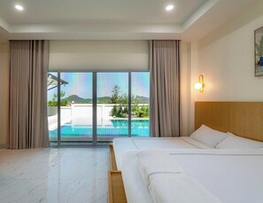 Ein Hotelzimmer mit Bett, Blick auf einen Swimmingpool und einem Balkon.