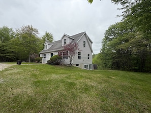 A two-story house with a front porch, a garage, and a well-maintained lawn.