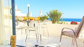 Una botella de Moët & Chandon y dos copas sobre una mesa, con vista a una terraza y al mar.