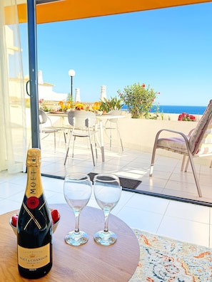 A bottle of Moët & Chandon champagne on a table with two glasses, overlooking a terrace with a view of the sea. - Boho Sea by BeCherish (Albufeira)