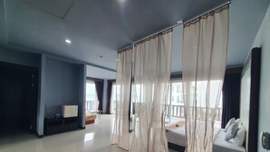 Amplia habitación de hotel con una cama grande, televisión y balcón con vistas.