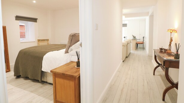 Een slaapkamer met een bed, nachtkastje en raam.