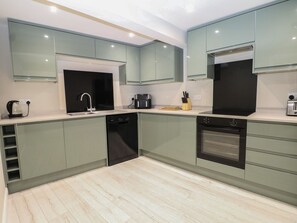 A modern kitchen with a dishwasher, oven, and coffee maker. - 2 Bed (Southampton)