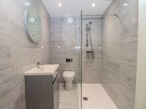 A modern bathroom with a glass shower enclosure, a white sink, and a toilet. - 2 Bed (Southampton)
