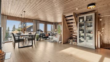 Un salón amplio con mesa de comedor, sofás y una escalera.