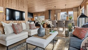 A cozy living room with a sofa, coffee table, and dining area.