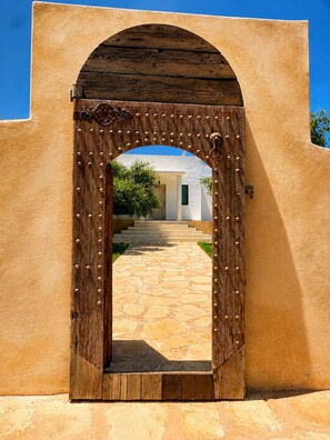 A wooden archway with a stone pathway leading to a building. - Palais Oriella (Essaouira)