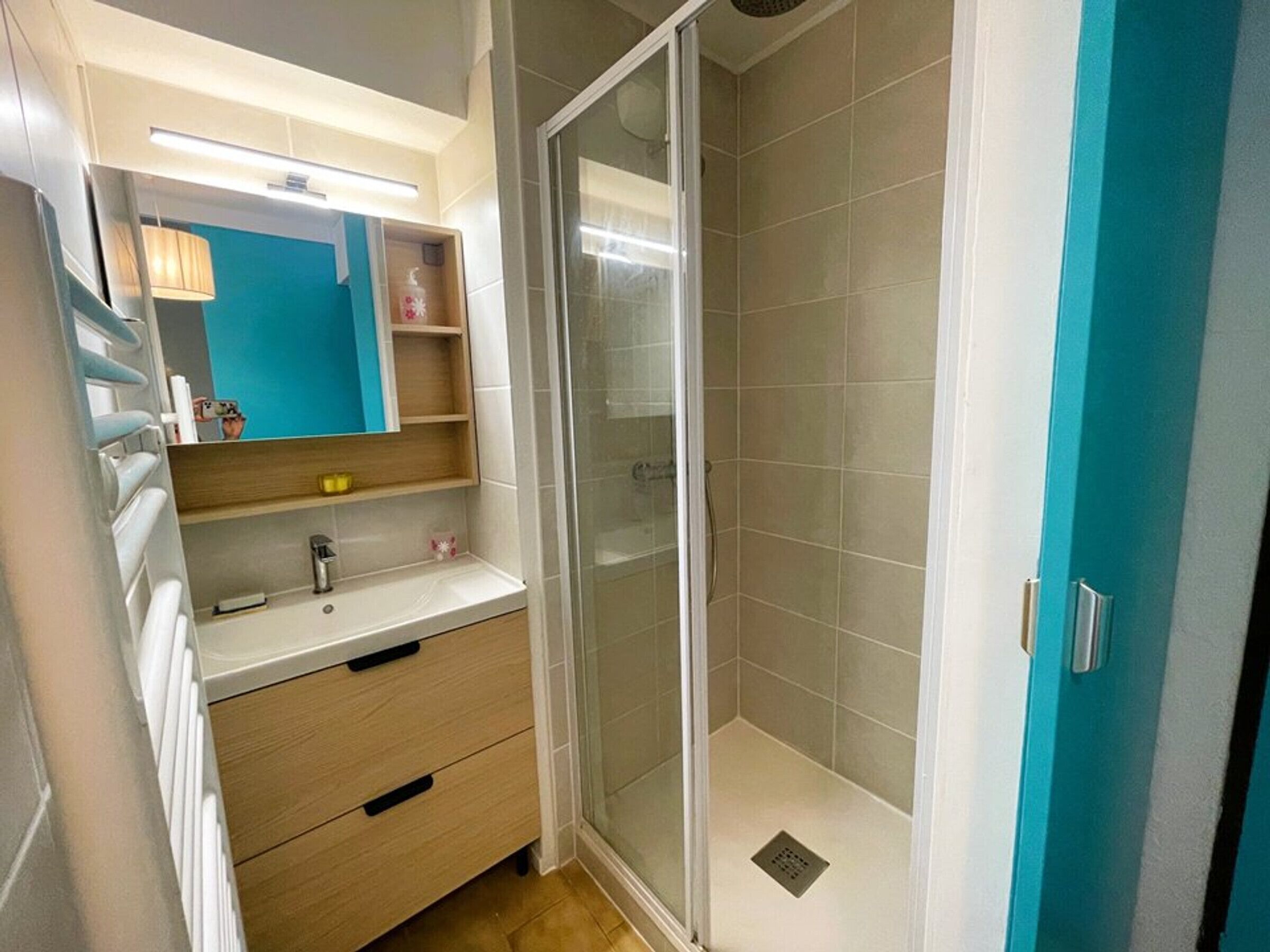 Un bagno con doccia, lavandino e specchio.