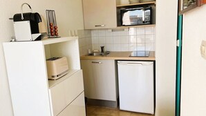 Un angolo cottura compatto con forno a microonde, tostapane e lavello.