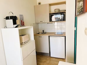 Eine kleine Küche mit Mikrowelle, Toaster und Spüle.