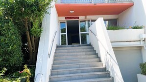 Una scala conduce all'ingresso di un edificio, con un cartello che riporta 'Port Jonathan'.