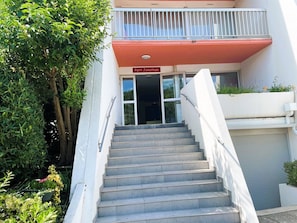 Eine Treppe führt zu einem Gebäudeeingang, an dem ein Schild 'Port Jonathan' angebracht ist.