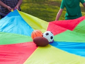 Une structure gonflable aux couleurs vives, sur laquelle sont représentés un ballon de basket et un ballon de football.