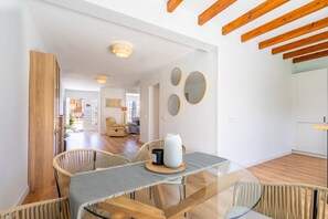 A modern dining area with a glass table, wicker chairs, and a wooden ceiling. - Mar - with private swimming pool (LLucmajor)