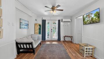 A hallway with a ceiling fan, a sofa, a small table, and a rug.